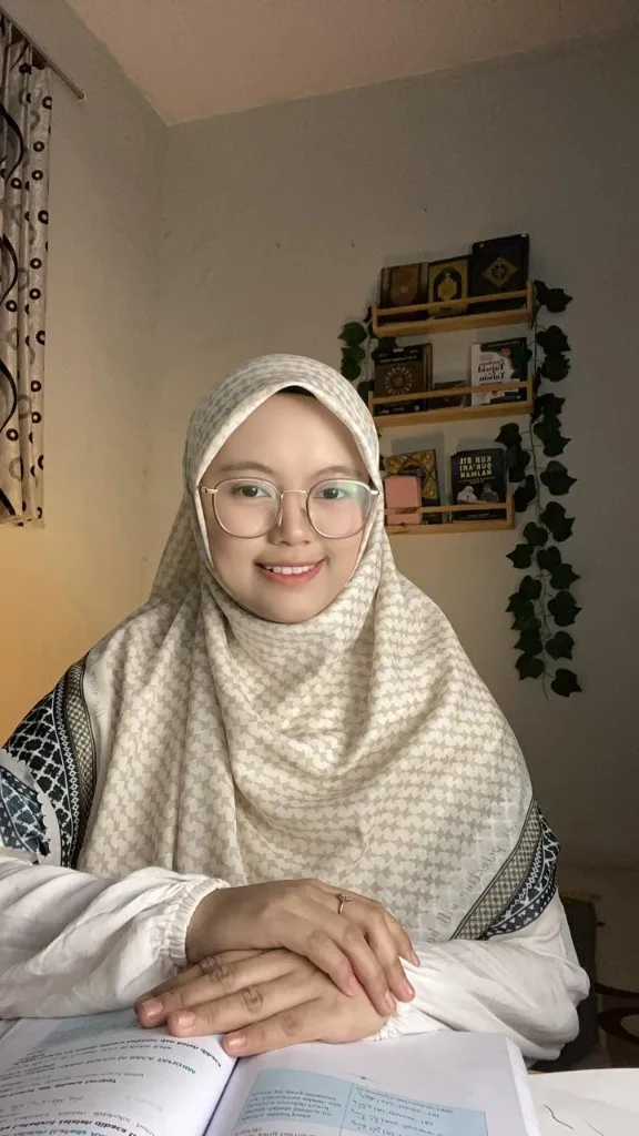 Ustadzah Novi Meisya Anggraeni, pendiri Tajweed Boost, tersenyum di meja belajarnya